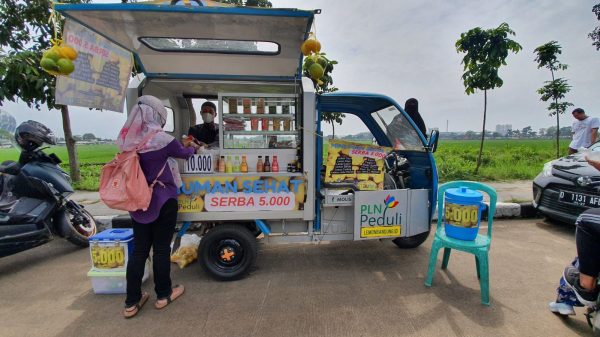 Salah seorang pelaku UMK olahan lemon di Bandung menggunakan bantuan motor listrik PLN untuk menjajakan produknya.