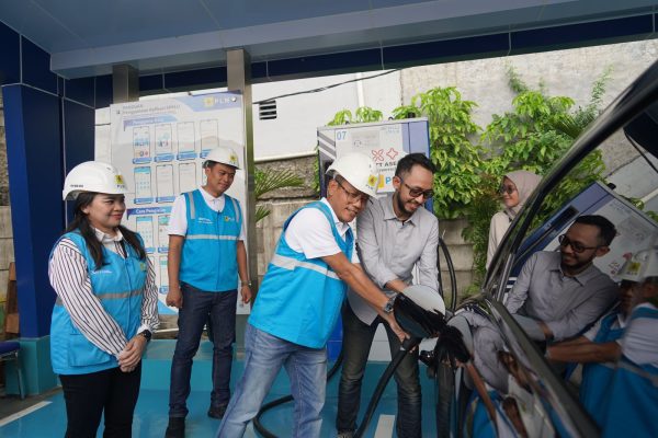 General Manager PLN Unit Induk Distribusi Jakarta, Lasiran membantu pemilik mobil listrik yang sedang mengisi baterai kendaraannya di Stasiun Pengisian Kendaraan Listrik Umum (SPKLU) Rest Area KM 6B Tol Jakarta - Cikampek.
