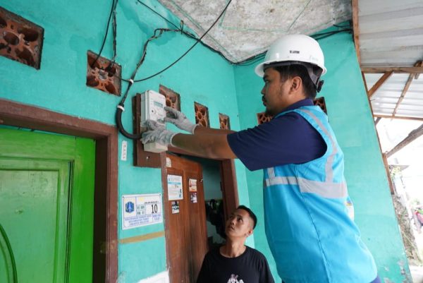 Petugas PLN sedang melakukan pemasangan kWh meter Advanced Metering Infrastructure (AMI) pada rumah pelanggan yang berada di daerah Jatinegara, Jakarta Timur.