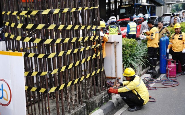 Sejumlah pekerja mulai membongkar tiang monorel di Jalan HR Rasuna Said, Jakarta, Rabu (14/1/2026). Pembongkaran 98 tiang monorel mangkrak selama lebih dari dua dekade ini dianggap mengganggu arus lalu lintas dan berpotensi menimbulkan kecelakaan, terutama di jalur lambat yang sering digunakan sepeda motor dan ojek online. (Beritakota.id)
