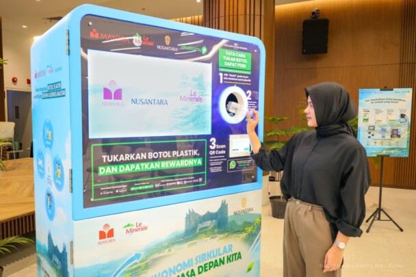 Peserta acara mencoba setor botol plastik ke mesin RVM